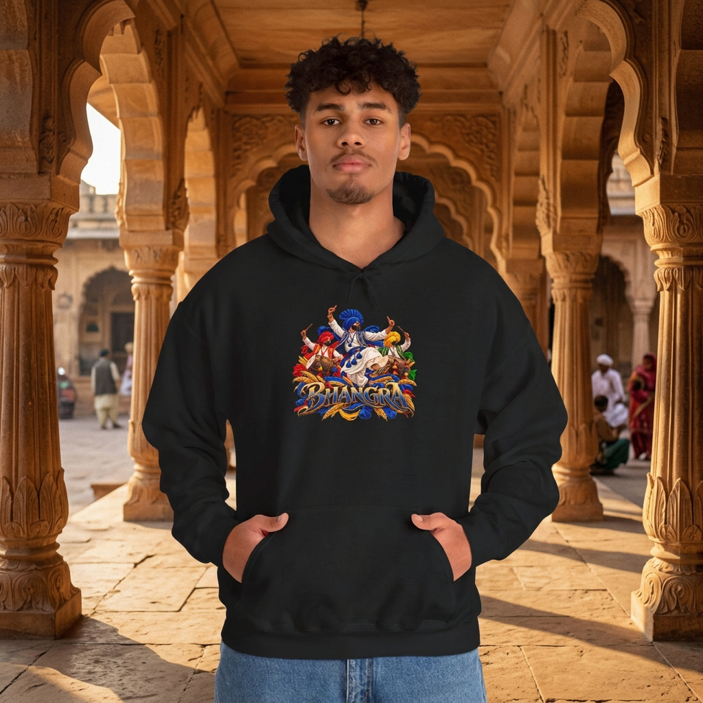 Model wearing a black hoodie with a colourful Bhangra dance graphic and BHANGRA lettering, photographed in a sunlit sandstone arcade.