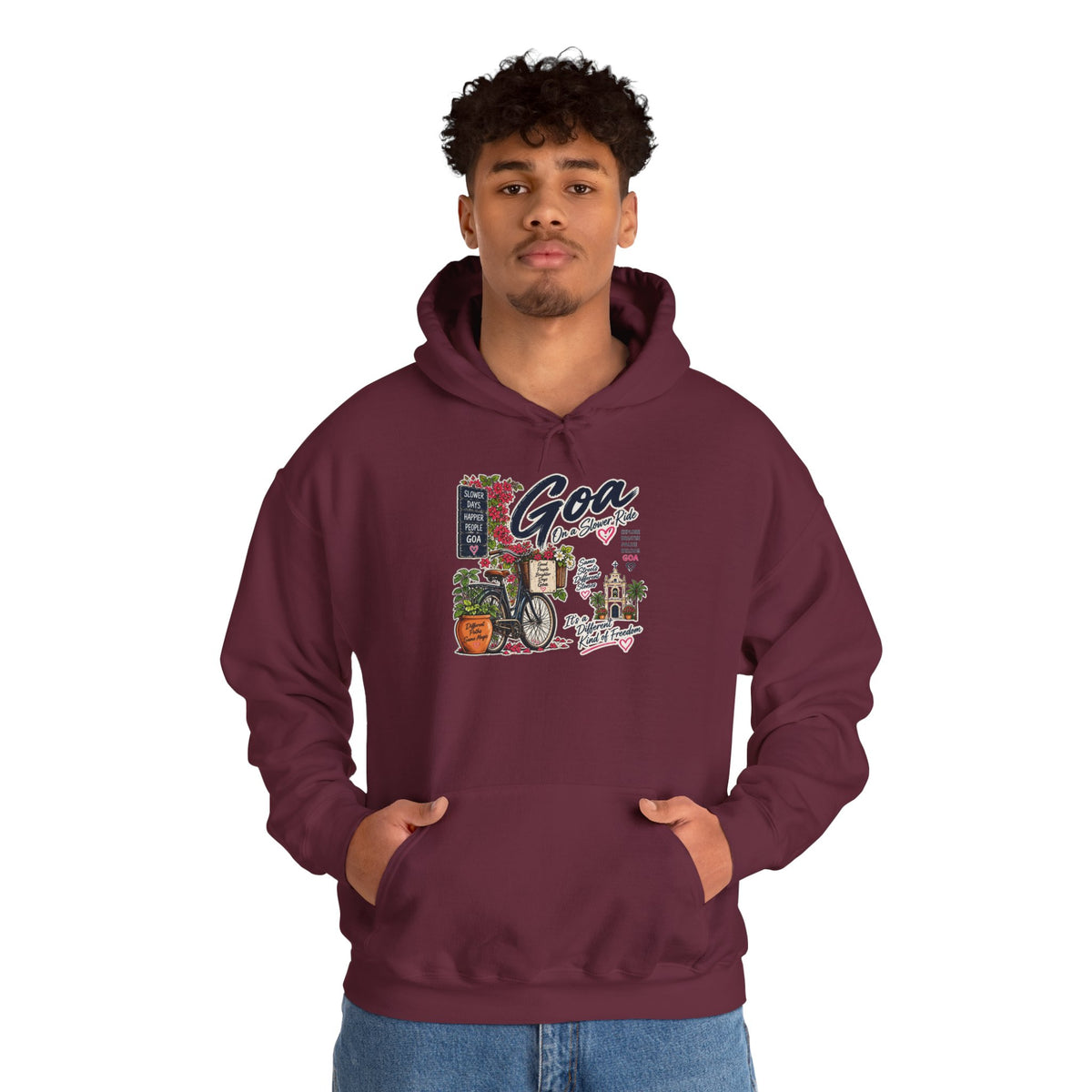 Model wearing a maroon Goa On a Slow Ride heavy blend hoodie with a bicycle and flower-filled street graphic.