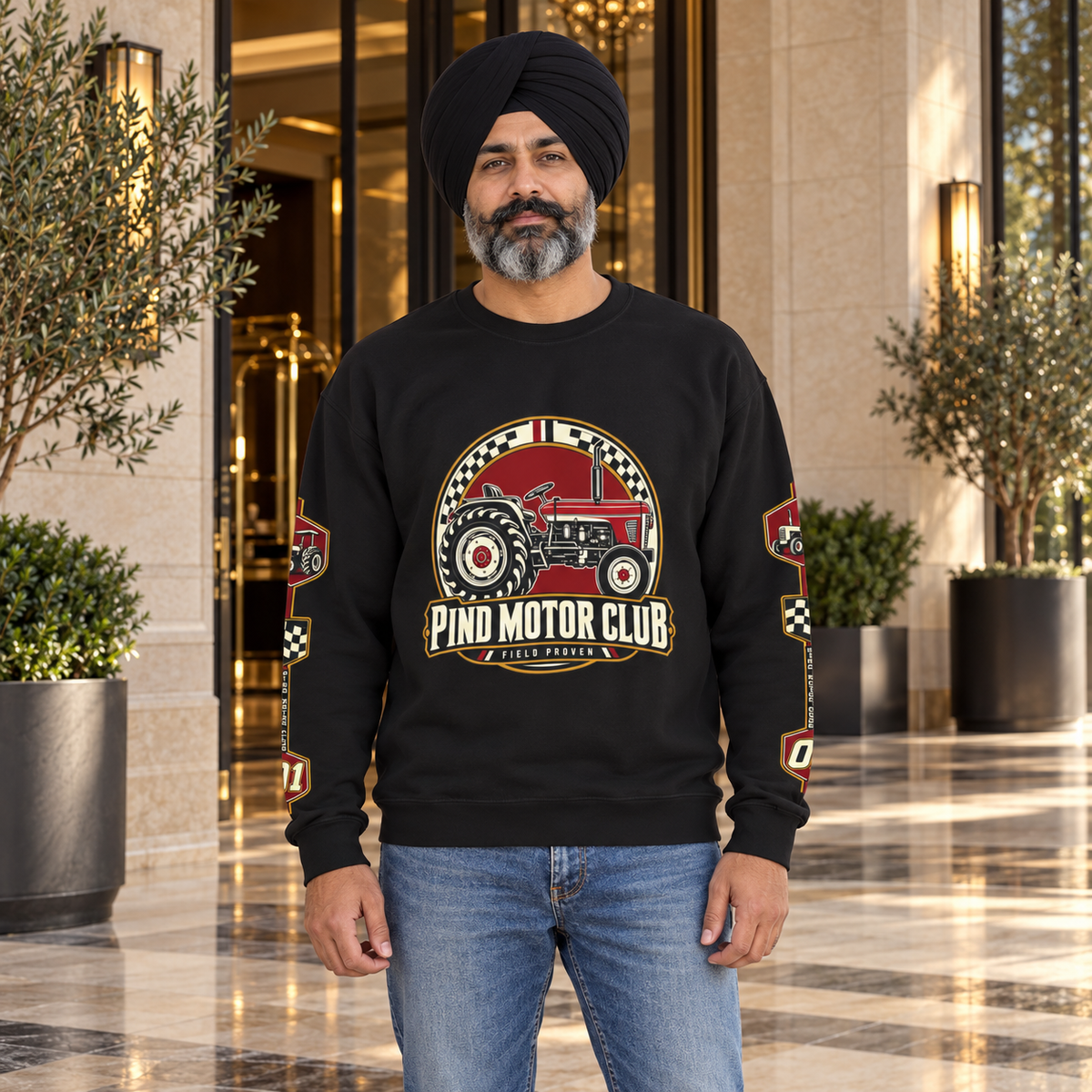 Pind Motor Club black tractor sweatshirt with centered front and sleeve prints, Sikh model at luxury hotel